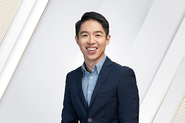 Man smiling at the camera in an office environment.